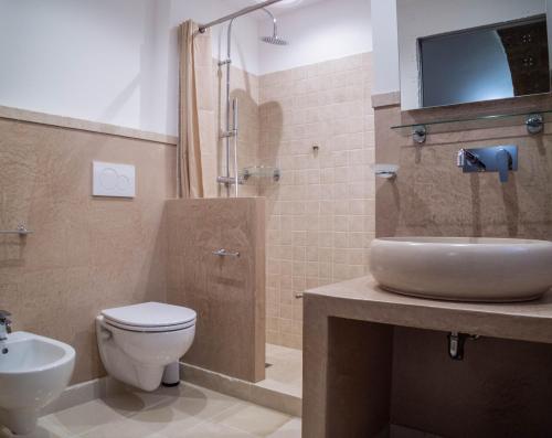 a bathroom with a toilet and a sink and a shower at Asylum Amicorum Bed & Breakfast in Gagliano del Capo