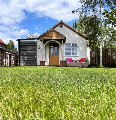 ein Haus mit einem Rasen davor in der Unterkunft Field's Edge in Swinderby