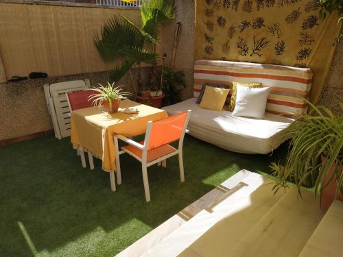 a patio with a bed and a table and a couch at La Casita de Nuria in Rincón de la Victoria