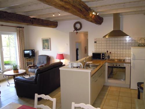 a kitchen and living room with a couch and a table at Gîte Le Gros Chêne in Bouillon