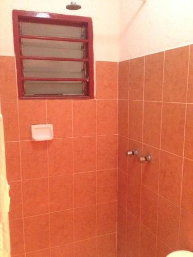 a bathroom with an orange tiled shower with a window at Hotel Xalapa in Veracruz