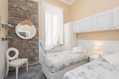een slaapkamer met 2 bedden en een spiegel bij Casamia in Agropoli