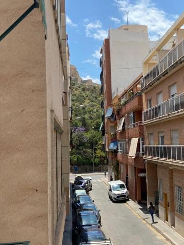 a row of cars parked on a street next to buildings at Apartamento centrico castillo s. Barbara in Alicante