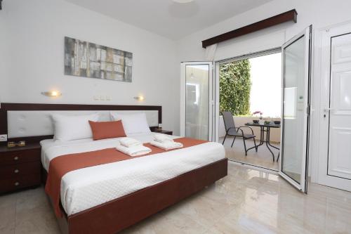 a bedroom with a large bed and a balcony at Villa Magda Maria in Pefkohori