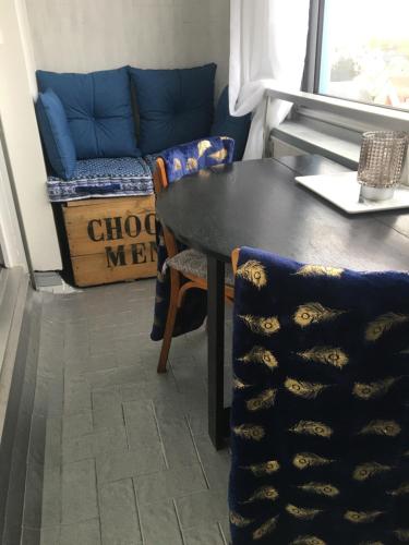 a dining room with a table and a couch at Studio 24 - Coucher de Soleil & Vue Mer in Courseulles-sur-Mer