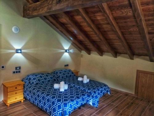 a bedroom with a bed with two pillows on it at Casa Rural Pambuches in Soto de Valdeón