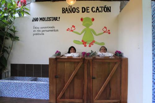 Deux filles se tiennent derrière une porte dans une salle de bains dans l'établissement Hostal Inti Luna, à Baños