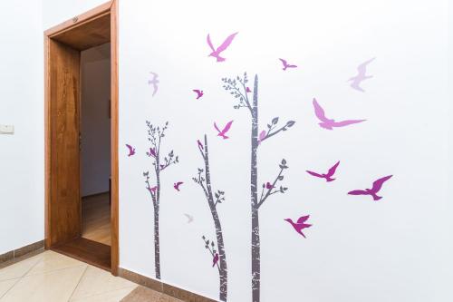 a wall with birds and trees stenciled on it at MB Bed&Breakfast in Pag