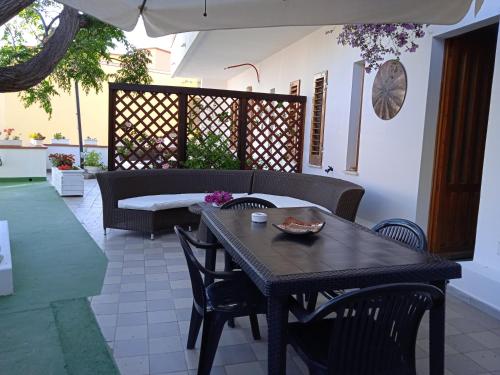 un patio con tavolo, sedie e un divano di Guest House Oleandro a Santa Maria Navarrese