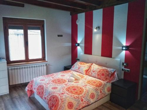 una camera con letto a righe rosse e bianche di Casa Rural Pambuches a Soto de Valdeón