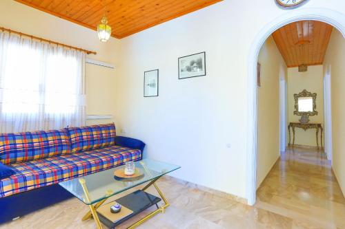 a living room with a couch and a glass table at Villa Kadith Agios Gordios in Agios Gordios