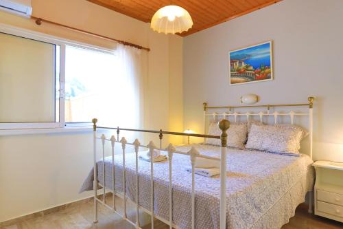 a bedroom with a bed and a window at Villa Kadith Agios Gordios in Agios Gordios