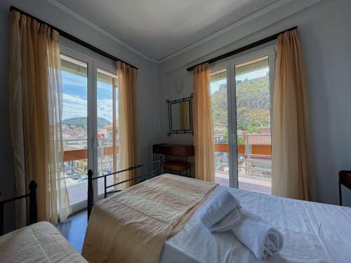 sypialnia z 2 łóżkami i dużym oknem w obiekcie Nafplia Hotel w Nauplionie