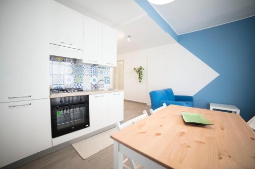 a kitchen with a wooden table and blue walls at GLBapartments in Capo dʼOrlando