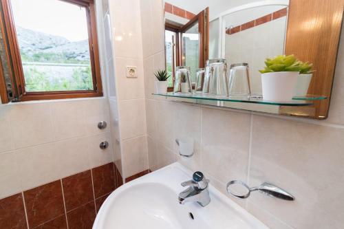 a bathroom with a sink and a mirror at MB Bed&Breakfast in Pag