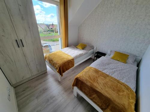 A bed or beds in a room at Domek pod świerkami - "Apartamenty świerkowe"