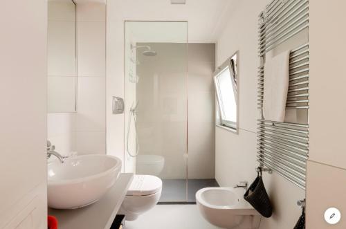 a white bathroom with a sink and a toilet at Bijoux Luxury Apartment in Old Town in Bari