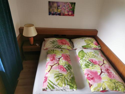 Una cama con dos almohadas encima. en Erlebnishof Tschabitscher, en Weissensee