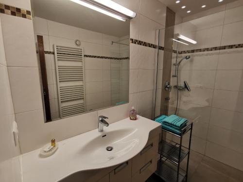 a white bathroom with a sink and a shower at Erlebnishof Tschabitscher in Weissensee