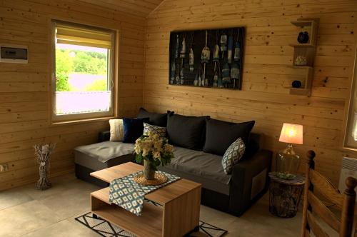 a living room with a couch and a table at Domek nad jeziorem, a morze w gratisie in Wisełka