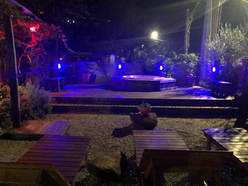 a backyard at night with blue lights and benches at Hotel Ferrugem Eco Village in Garopaba