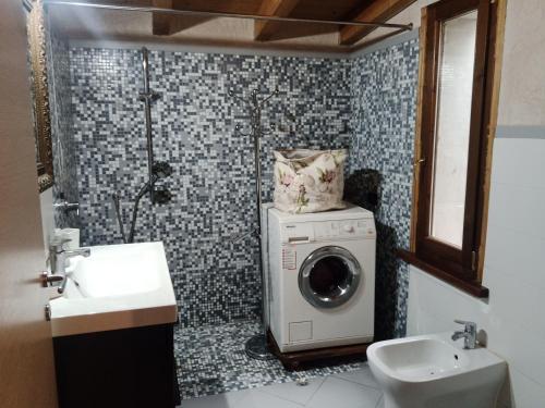 a bathroom with a washing machine and a sink at casa nonni in Mantova