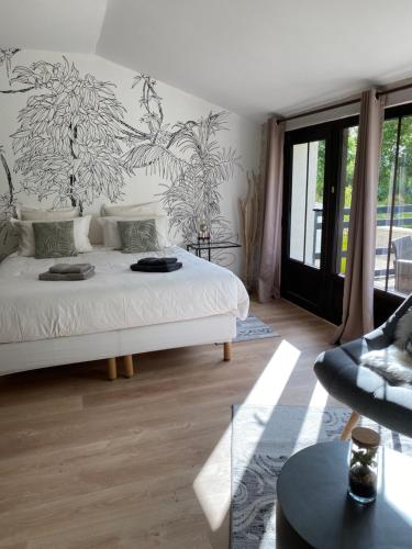 a bedroom with a white bed and a couch at La Chaumeauniere in Aigrefeuille-dʼAunis