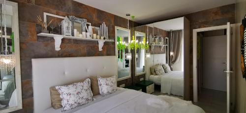 een slaapkamer met een wit bed en een kamer met een bank bij Apartment Orlando Torviscas Bajo in Adeje