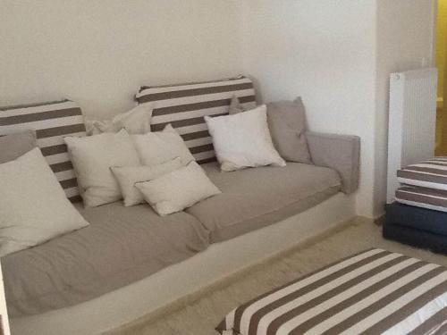 a couch with white pillows in a room at PyleanBlue villas in Pylos