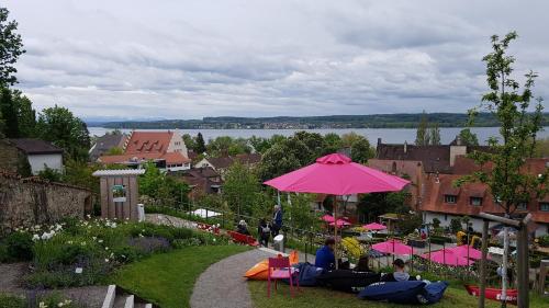 a group of people sitting under a pink umbrella at Loft Orchidee in Überlingen
