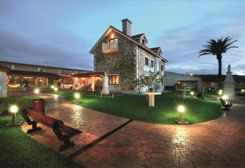 a building with a park bench in front of it at Hotel Rural Finca Aldeola in Malpica