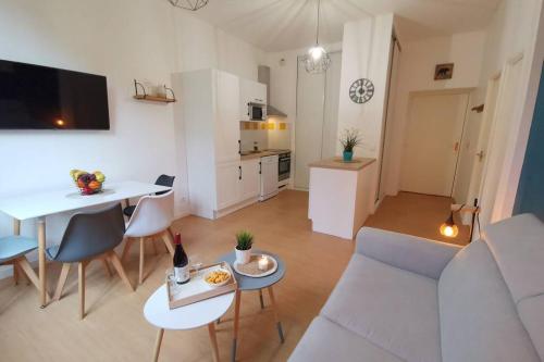 un soggiorno con un divano, un tavolo e una cucina di NOUVEAU ! MAGNIFIQUE T2 FACE AUX THERMES ad Aulus-les-Bains