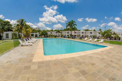 a swimming pool with lounge chairs and a resort at Departamento Planta Baja con parqueo en Condominio in Santa Cruz de la Sierra
