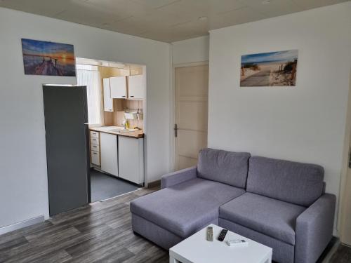un salon avec un canapé et une cuisine dans l'établissement Appartement T3, cosy, climatisé, équipé avec goût, à Avignon