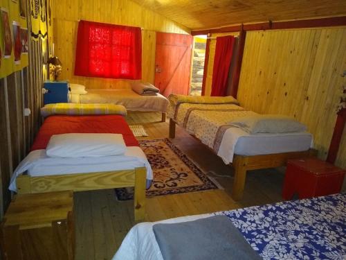 Habitación con 3 camas en una habitación de madera en Hostel Armazém do Heyokah, en Urubici
