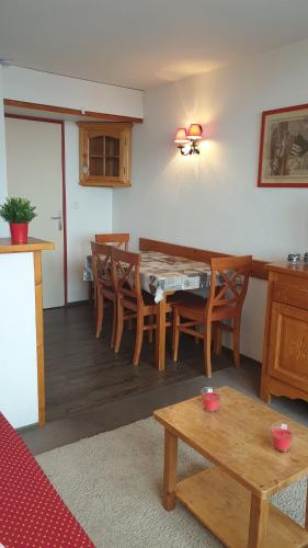 a living room with a table and wooden chairs at Appartement Alpe d'huez in LʼHuez