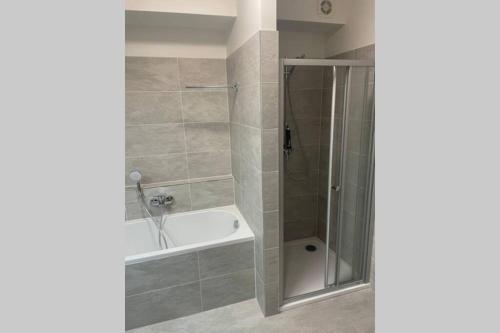 a bathroom with a shower and a tub and a sink at Apartmán za kostelem Čeladná in Čeladná