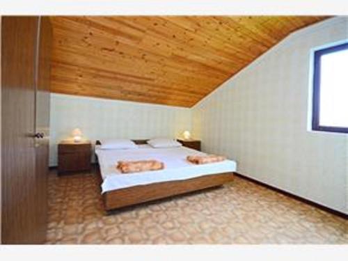 ADRIATIC apartmani A2-A6, RAB في راب: غرفة نوم بها سرير ووسادتين عليه