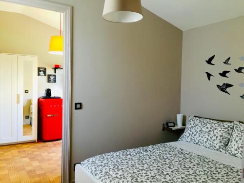 um quarto com uma cama e um frigorífico vermelho em PILOTTA's Balcony em Parma