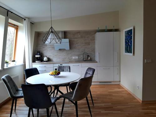 a kitchen with a table and chairs in a room at Aqua apartments in Druskininkai