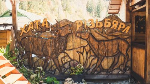 a wall with a painting of animals on it at Хата Різьбяра - Закуток in Beloberëzka