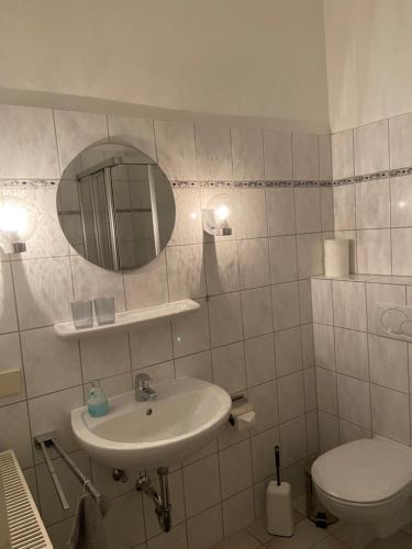 La salle de bains est pourvue d'un lavabo, de toilettes et d'un miroir. dans l'établissement Ferienwohnung Elias, à Goslar
