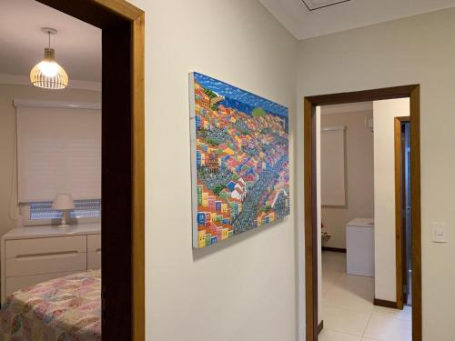 une peinture accrochée au mur dans une chambre dans l'établissement Casa em condomínio fechado, com piscina privativa em Juquehy, à São Sebastião