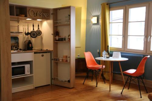 a kitchen with a table and chairs and a table and a window at Maison Cliquot - Appartements Colmar Centre in Colmar