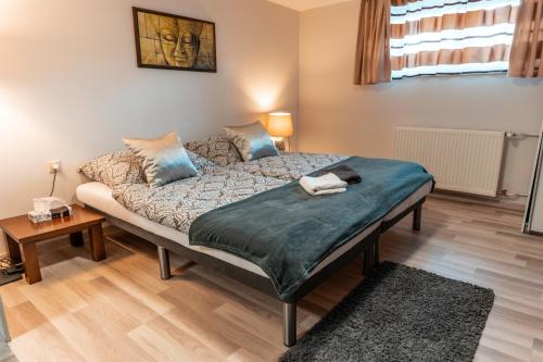 a bedroom with a bed with a green blanket on it at Buddha Residence in Sopron