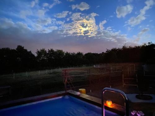 a view of a pool with the moon in the sky at Hof Vierzehnender im Hohen Venn - 70qm Maisonette - 2 Schlafzimmer - Wohnküche - Balkon mit Grill - Monschau - Eifel - Hunde willkommen - Islandpferde in Monschau