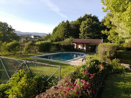 een tuin met een zwembad en een huis bij Casa De Fatauncos in Vouzela