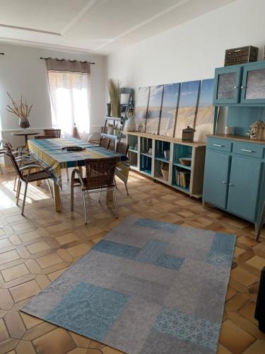 un salon avec une table et des chaises et une cuisine dans l'établissement Appartement la corde a linge Gruissan village avec terrasses, à Gruissan