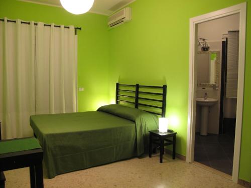 una camera verde con letto e bagno di Arches Inn a Roma