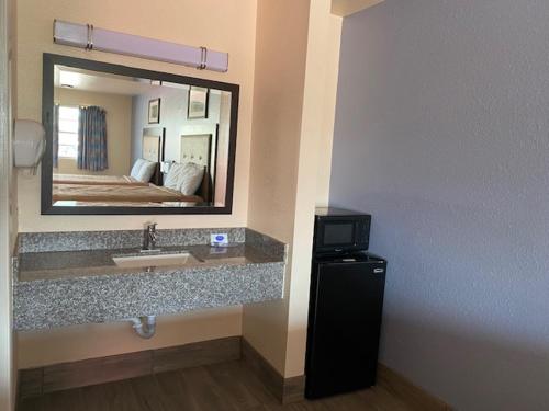 a hotel bathroom with a sink and a mirror at Texas Inn Seguin in Seguin